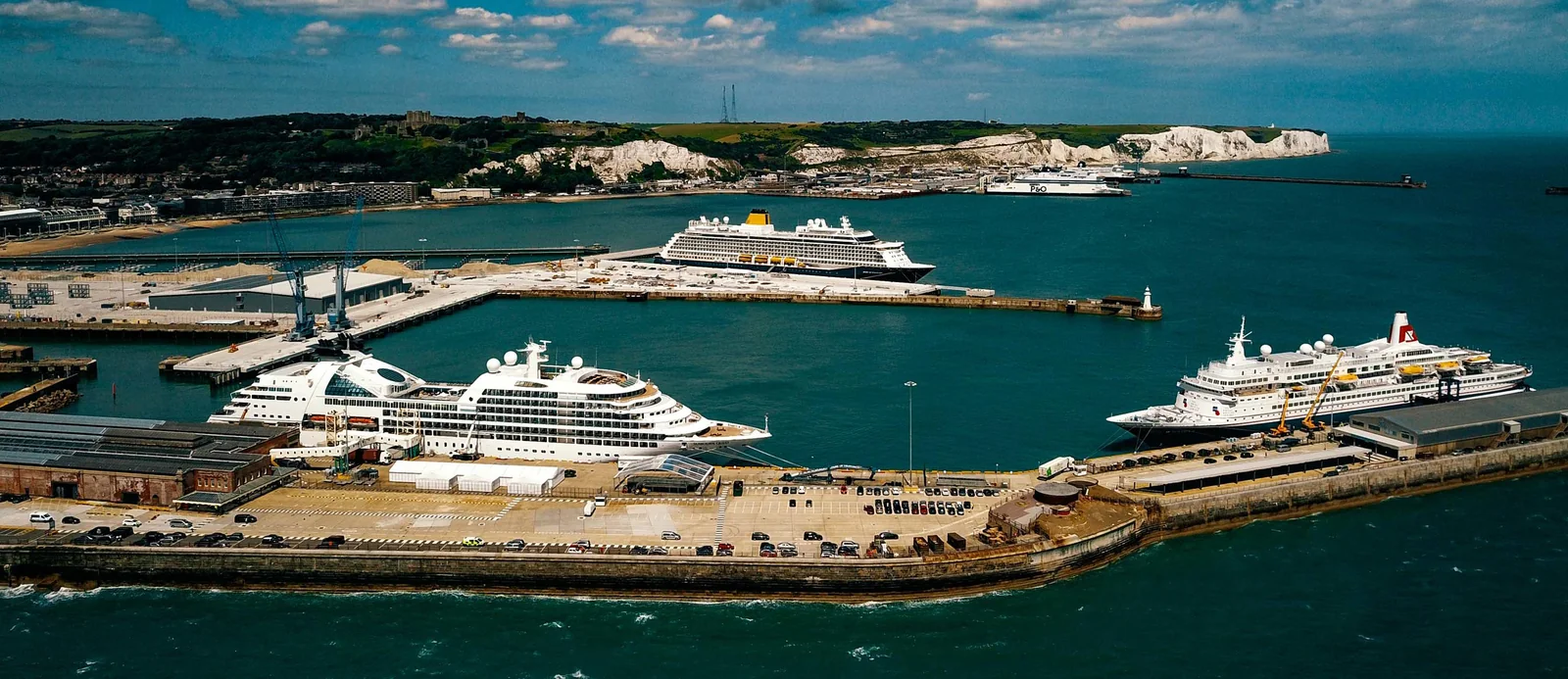 Cruise ships berthed in Dover harbour with the White Cliffs in the background